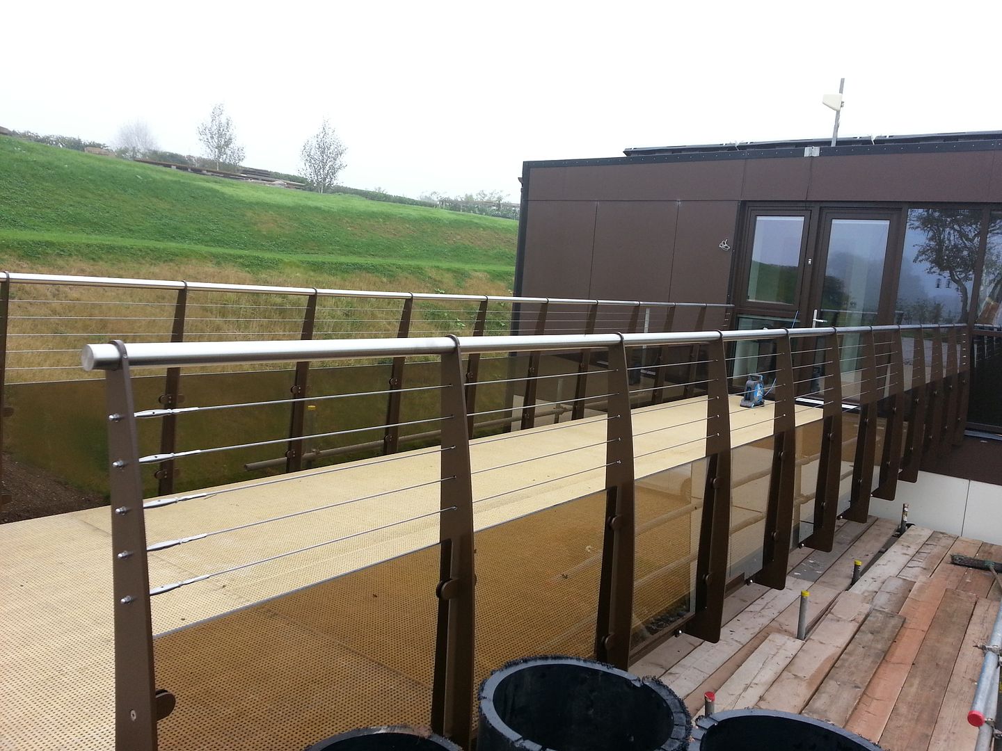 Bespoke bridge balustrade with tension wires and bronze glass