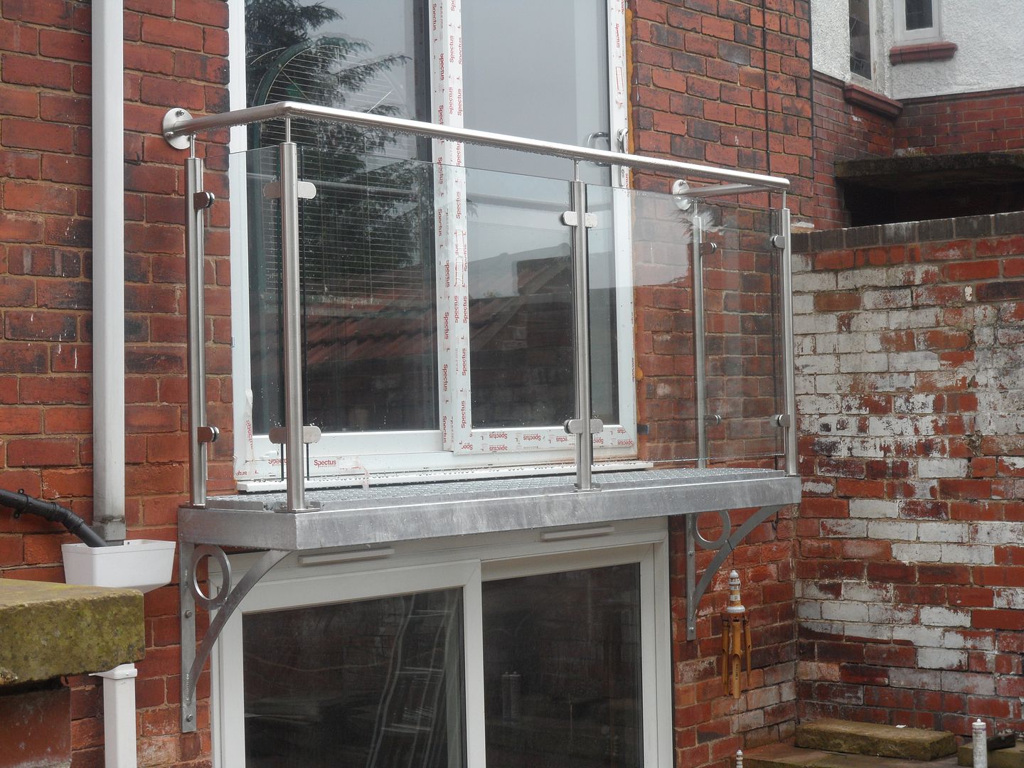 Walk out balcony balustrade with mesh flooring and glass balustrade
